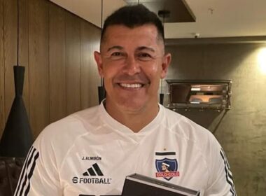 Primer plano de Jorge Almirón sonriente con camiseta de Colo-Colo.