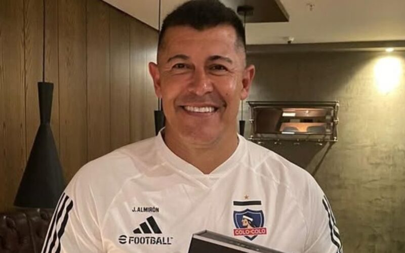 Primer plano de Jorge Almirón sonriente con camiseta de Colo-Colo.