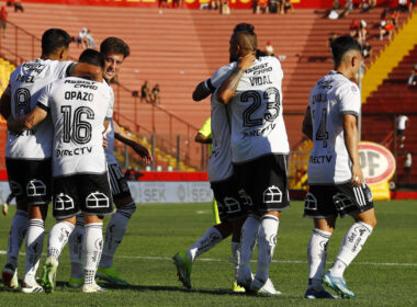 Jugadores de Colo-Colo abrazados celebrando un gol.