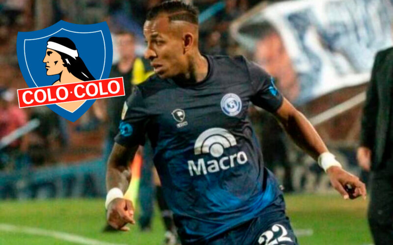 Sebastián Villa jugando por Independiente Rivadavia junto al escudo de Colo-Colo.