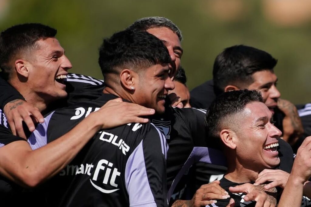 Jugadores de Colo-Colo abrazados durante un entrenamiento.