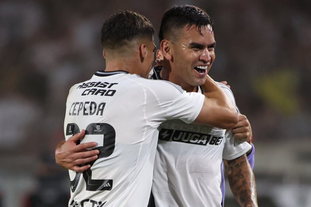 Jugadores de Colo-Colo abrazados celebrando un gol.