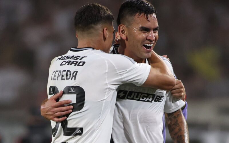 Jugadores de Colo-Colo abrazados celebrando un gol.