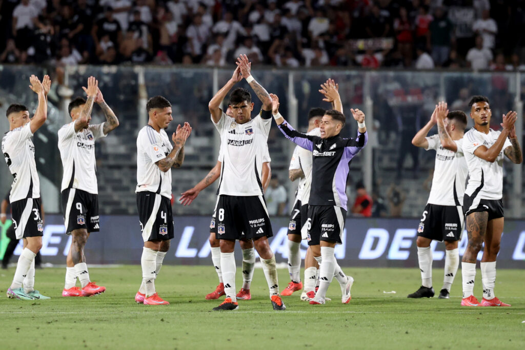 Jugadores de Colo-Colo con los brazos en el aire despidiéndose de los hinchas.