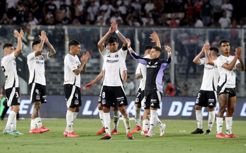 Jugadores de Colo-Colo con los brazos en el aire despidiéndose de los hinchas.