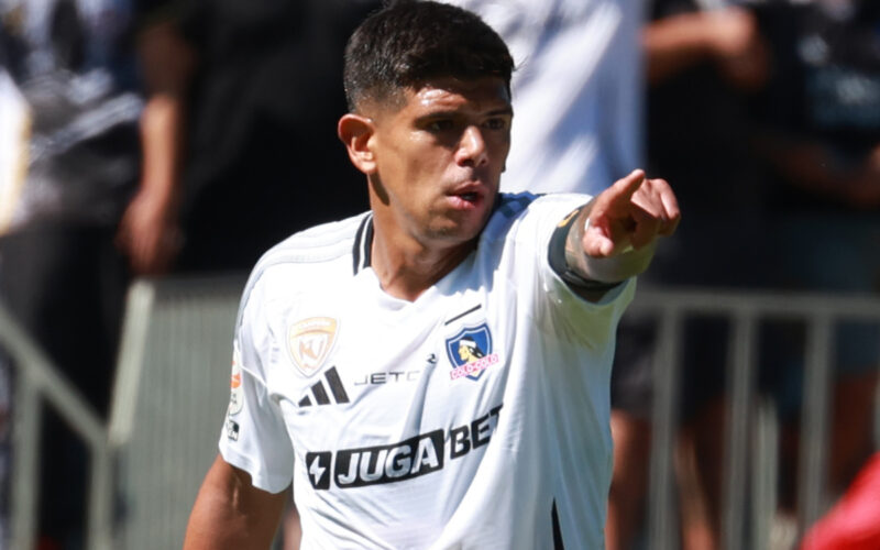 Esteban Pavez con camiseta de Colo-Colo y apuntando con el dedo.