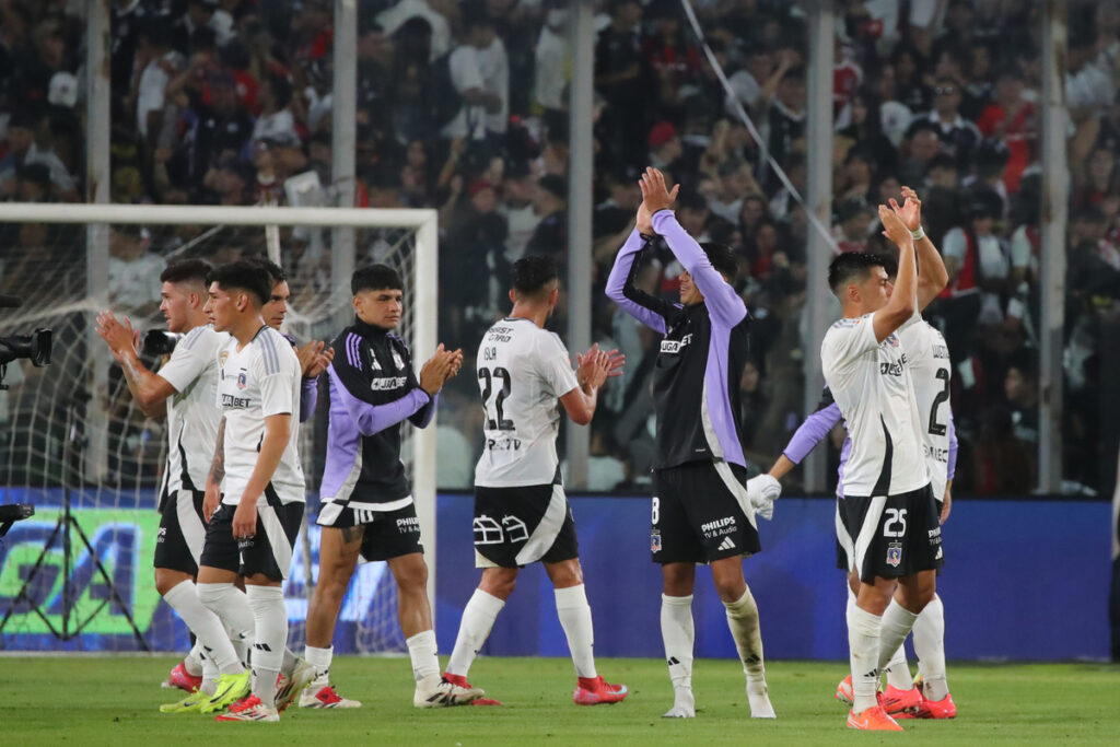 Jugadores de Colo-Colo con los brazos en el aire despidiéndose de los hinchas.