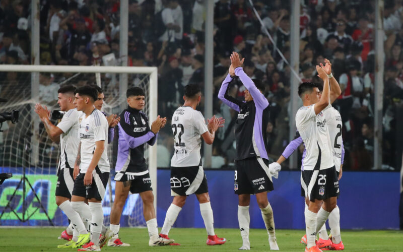 Jugadores de Colo-Colo con los brazos en el aire despidiéndose de los hinchas.