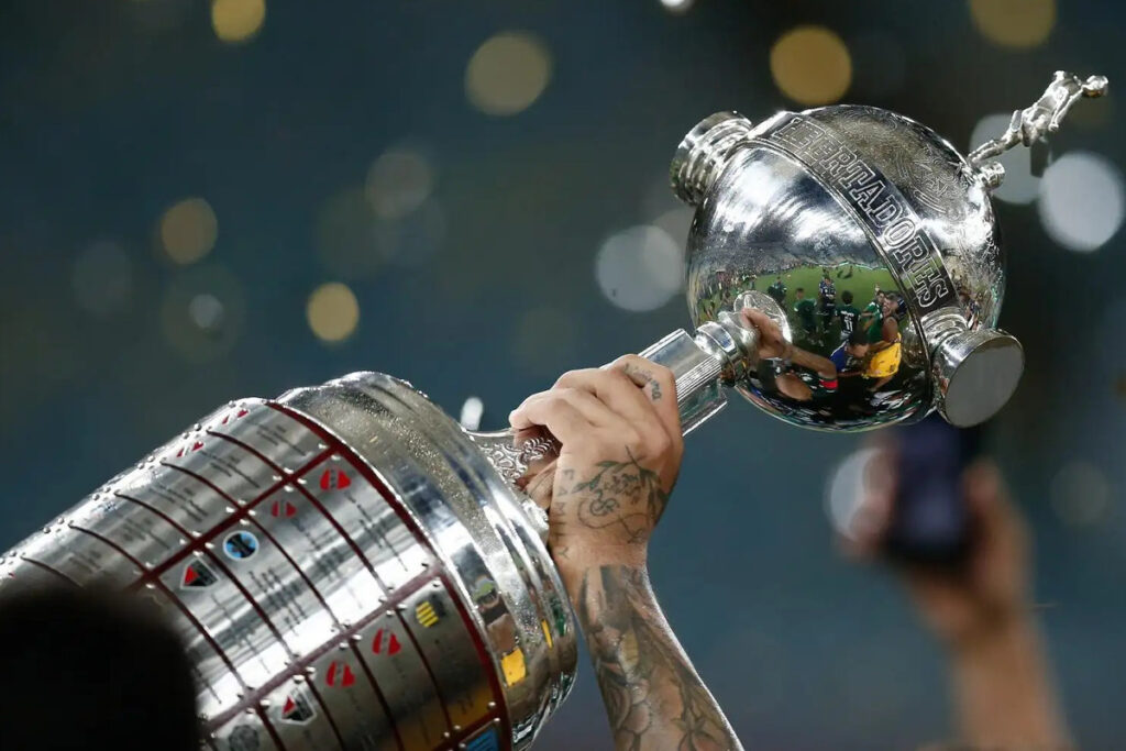 Trofeo de la Copa Libertadores siendo levantada por un equipo campeón.